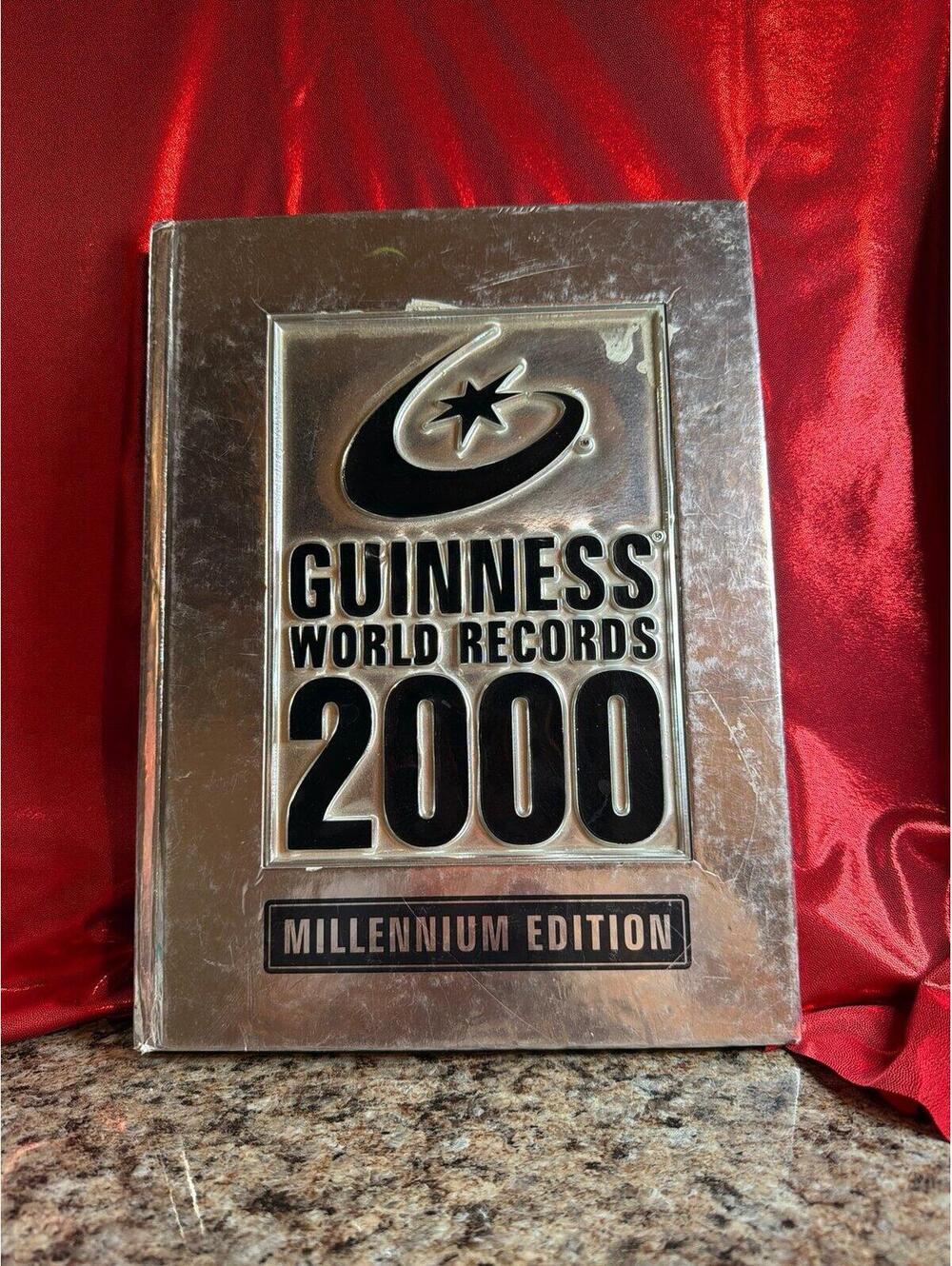 Guinness World Records 2000 Millennium Edition hardcover book, featuring a disti